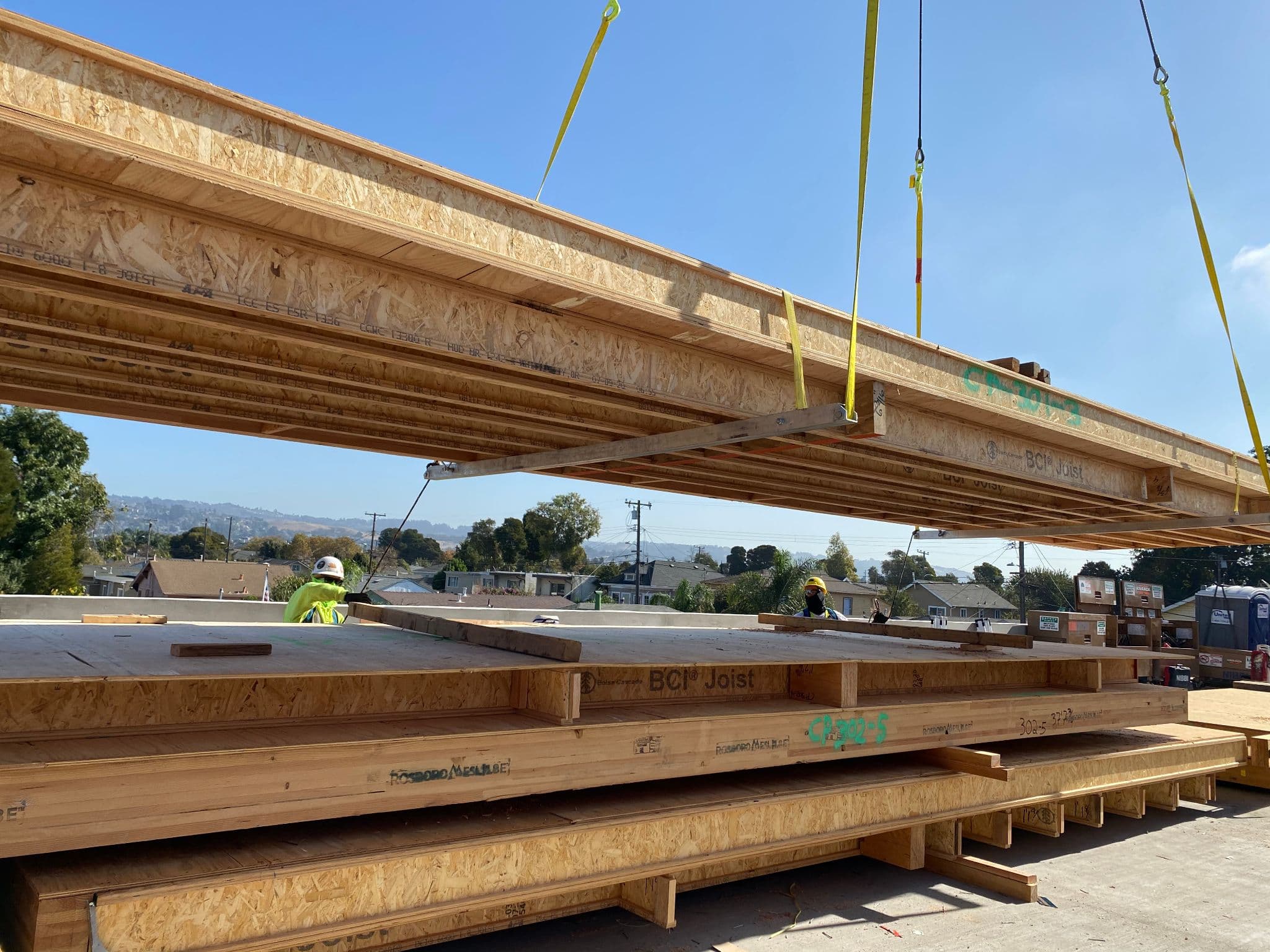 Crane setting floor cassette onto multi-story building