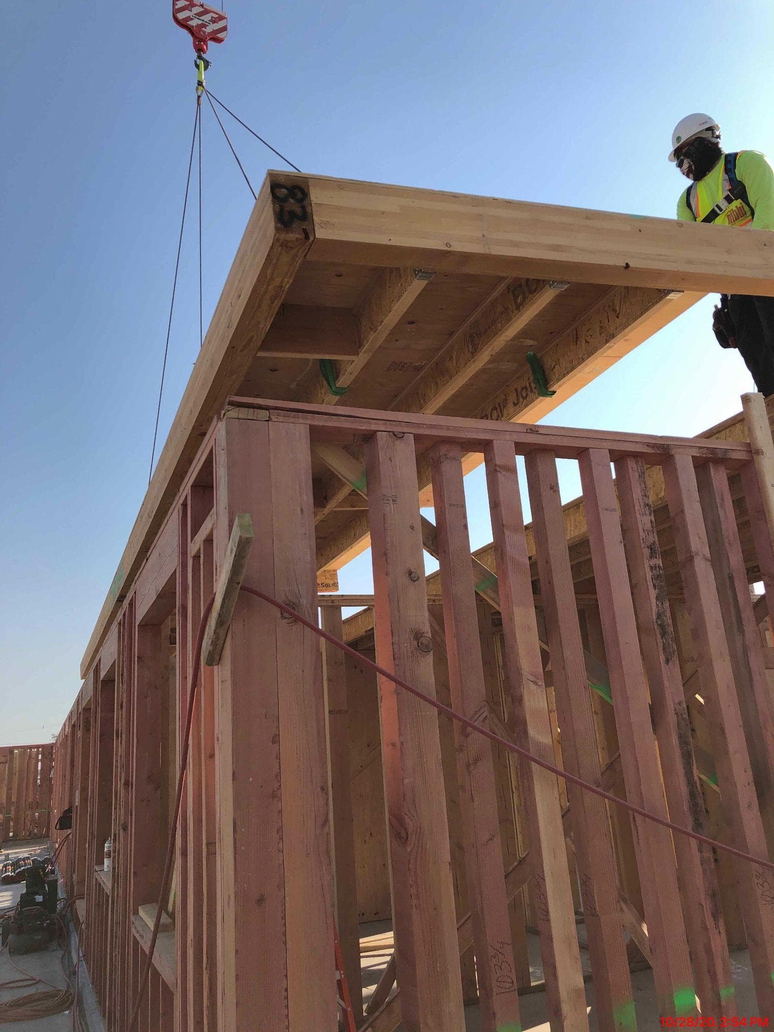 Worker guiding wall panel into position