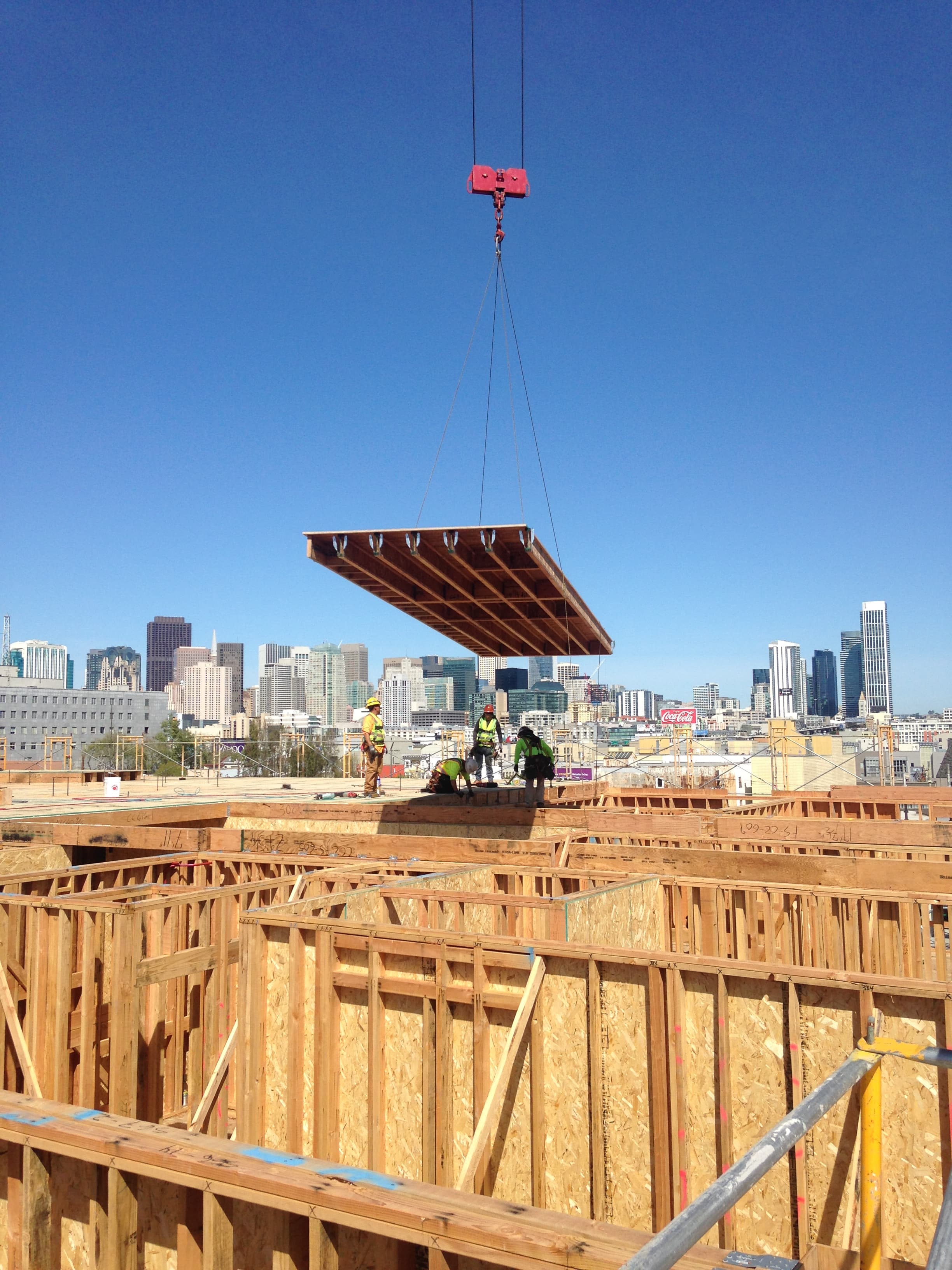 NCC crane lifting a floor cassette with city skyline in background
